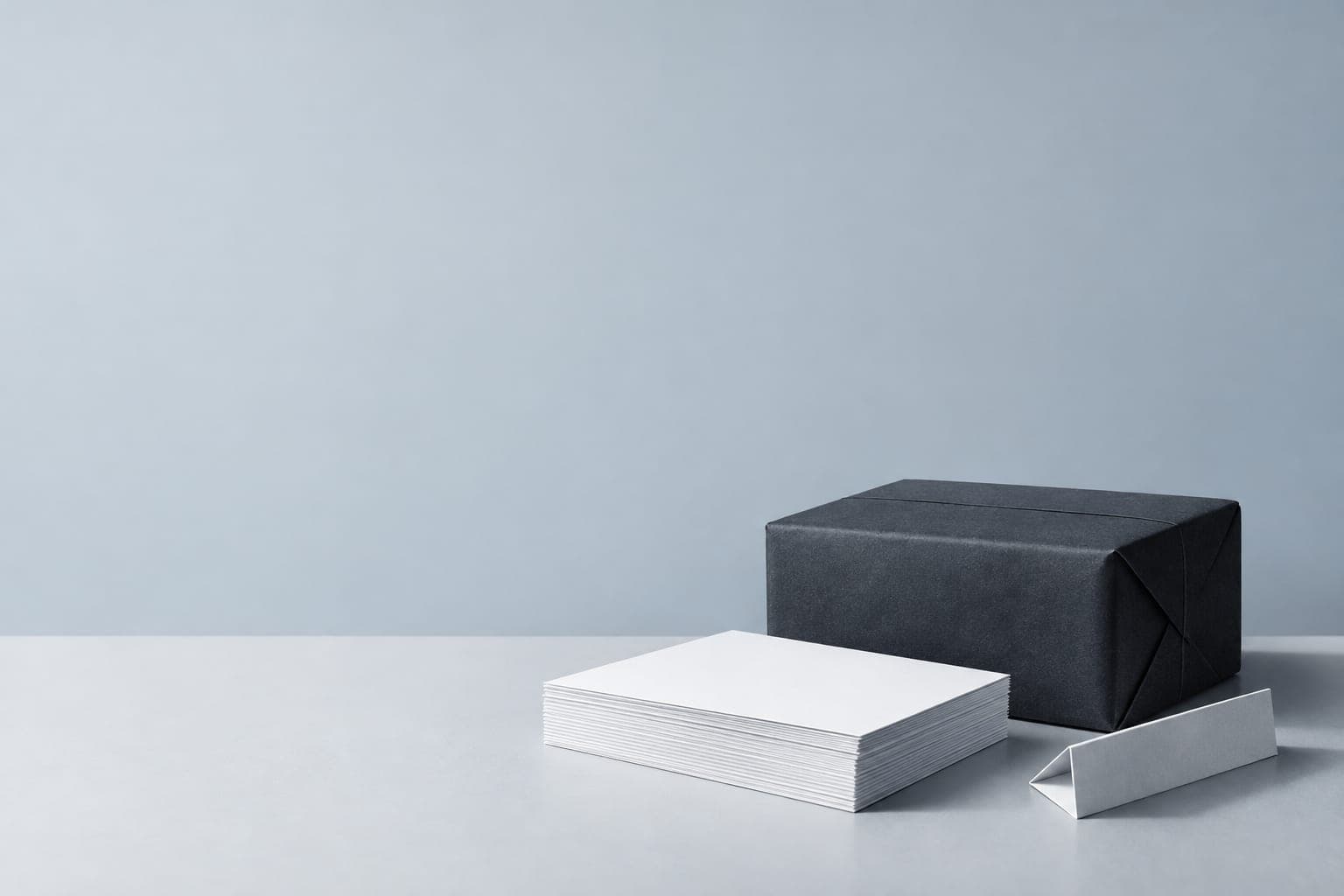 Illustration of a dark parcel, stacked white sheets and folded paper.